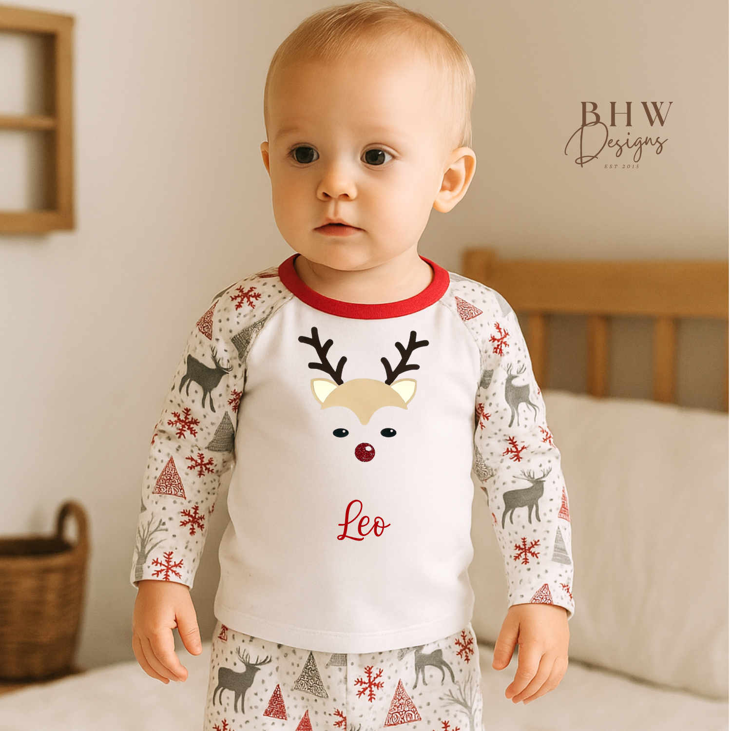 Baby wearing a pyjama set with a reindeer design and 'Leo' text. 
