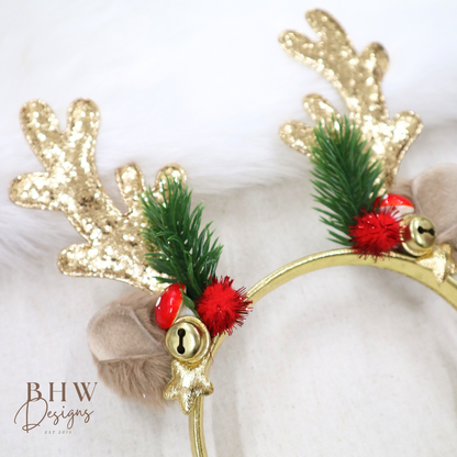 Gold reindeer antlers with green leaves and red berries on a white background, featuring the brand 'BHW Designs'.