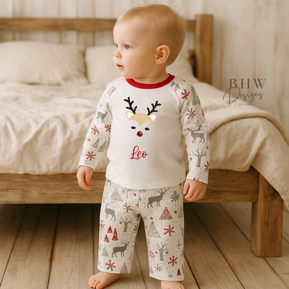 Child wearing a pajama set with reindeer pattern in a bedroom setting