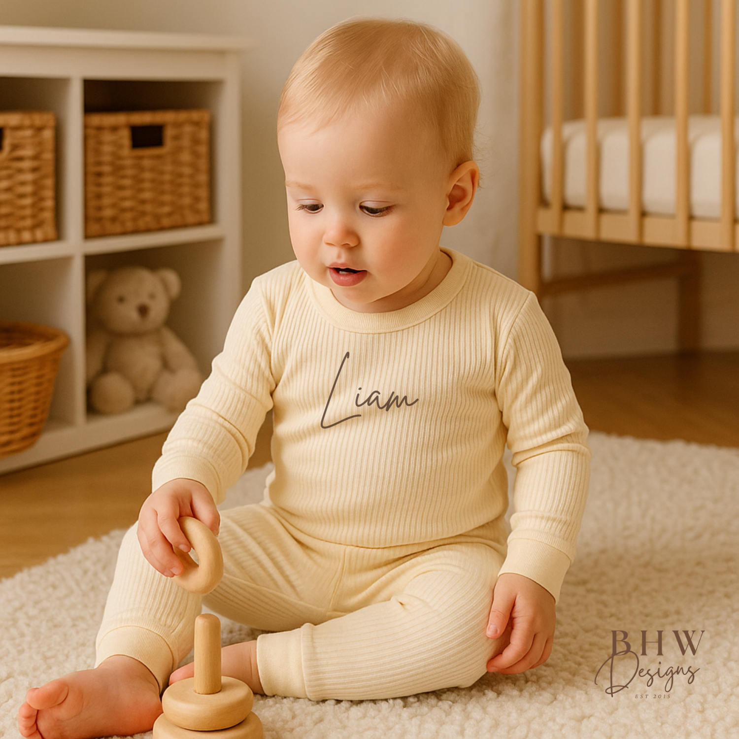Baby sitting on a rug playing with wooden toys wearing a personalised ribbed cream outfit