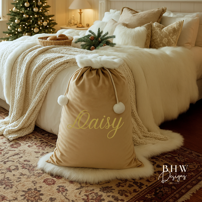 personalised beige velvet Santa sack and  bed in a festively decorated room with Christmas tree and garland.