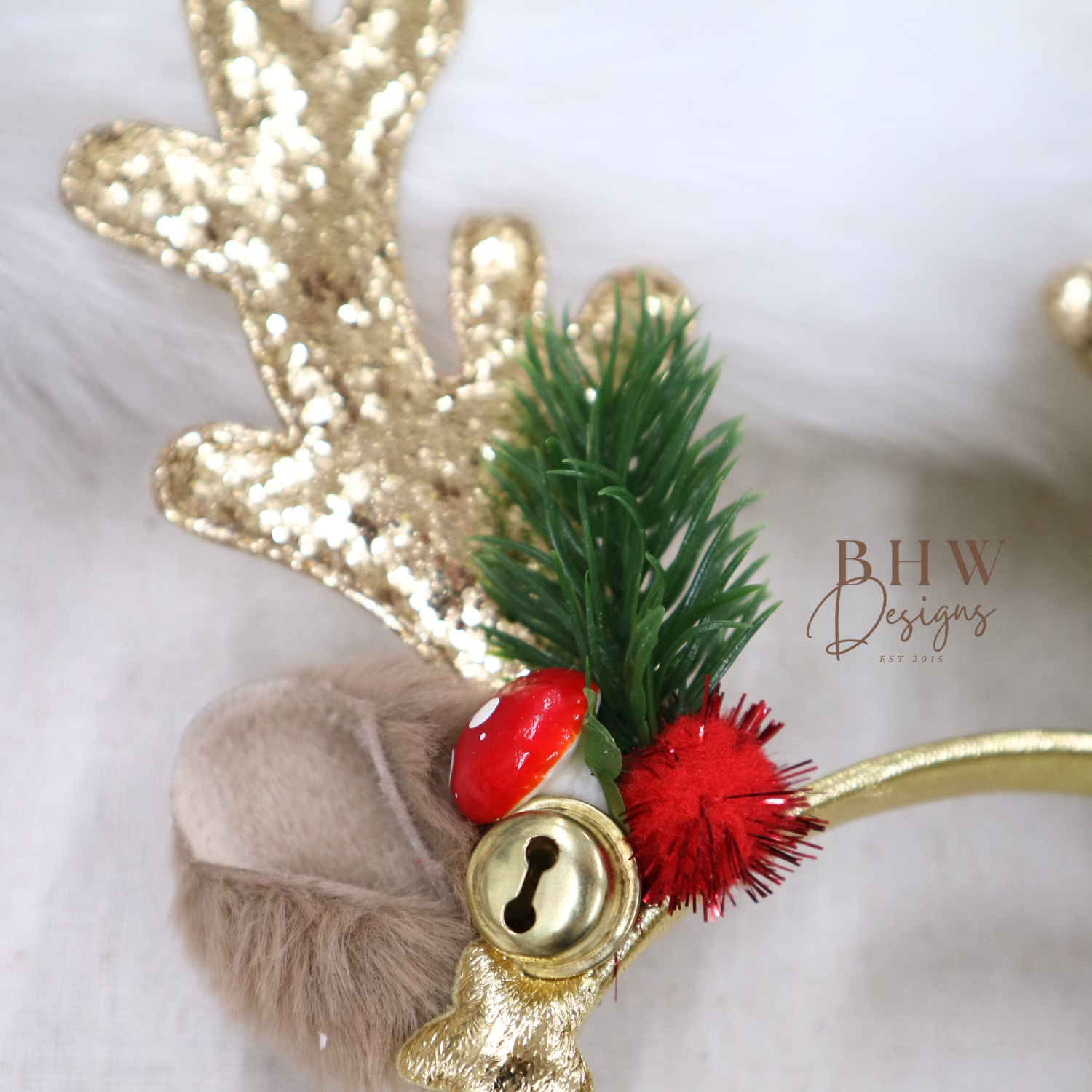 Gold reindeer headband with red and green decorations on a white background