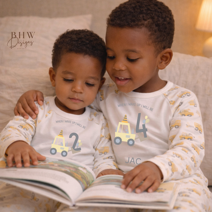 Two children in matching pajamas reading a book together