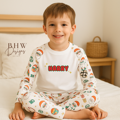 Child wearing a white pyjama set with 'Harry' printed on it in a funky christmas print sitting on a bed.