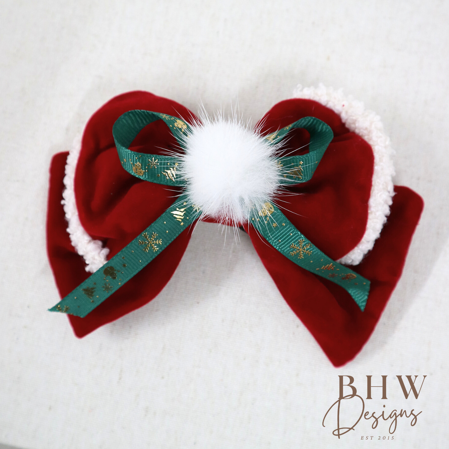 Red velvet bow with green ribbon and white pom-pom 