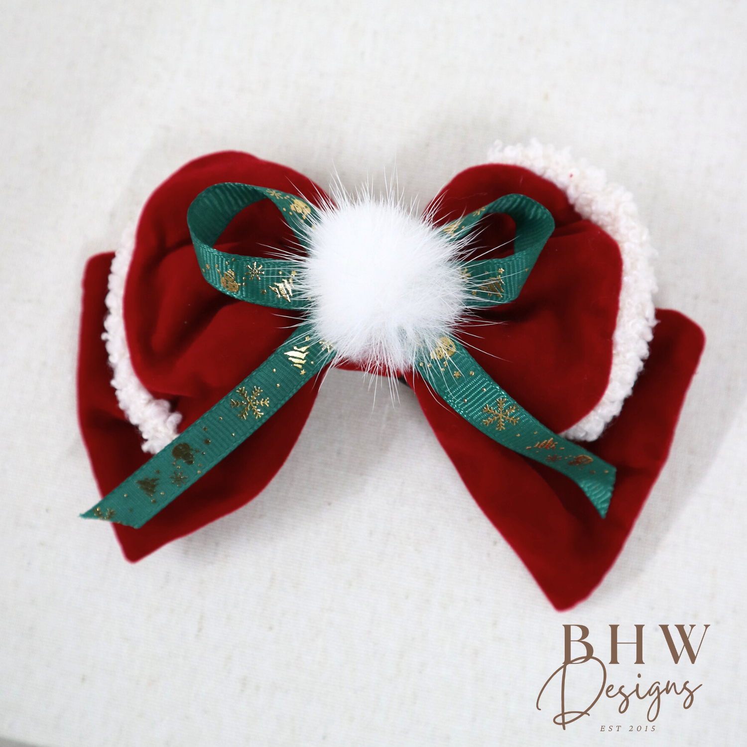 Red velvet bow with green ribbon and white pom-pom 