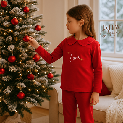 Child wearing red pyjamas with lace detail collar personalised n white with gold glitter stars 