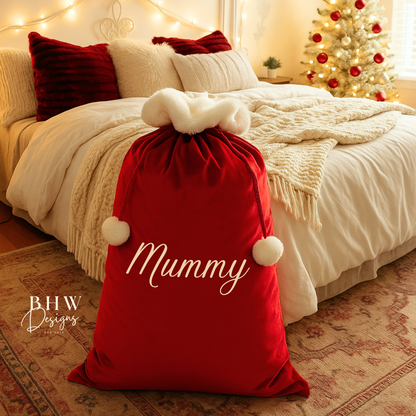 Red sack labeled 'Mummy' on a bed with Christmas decorations