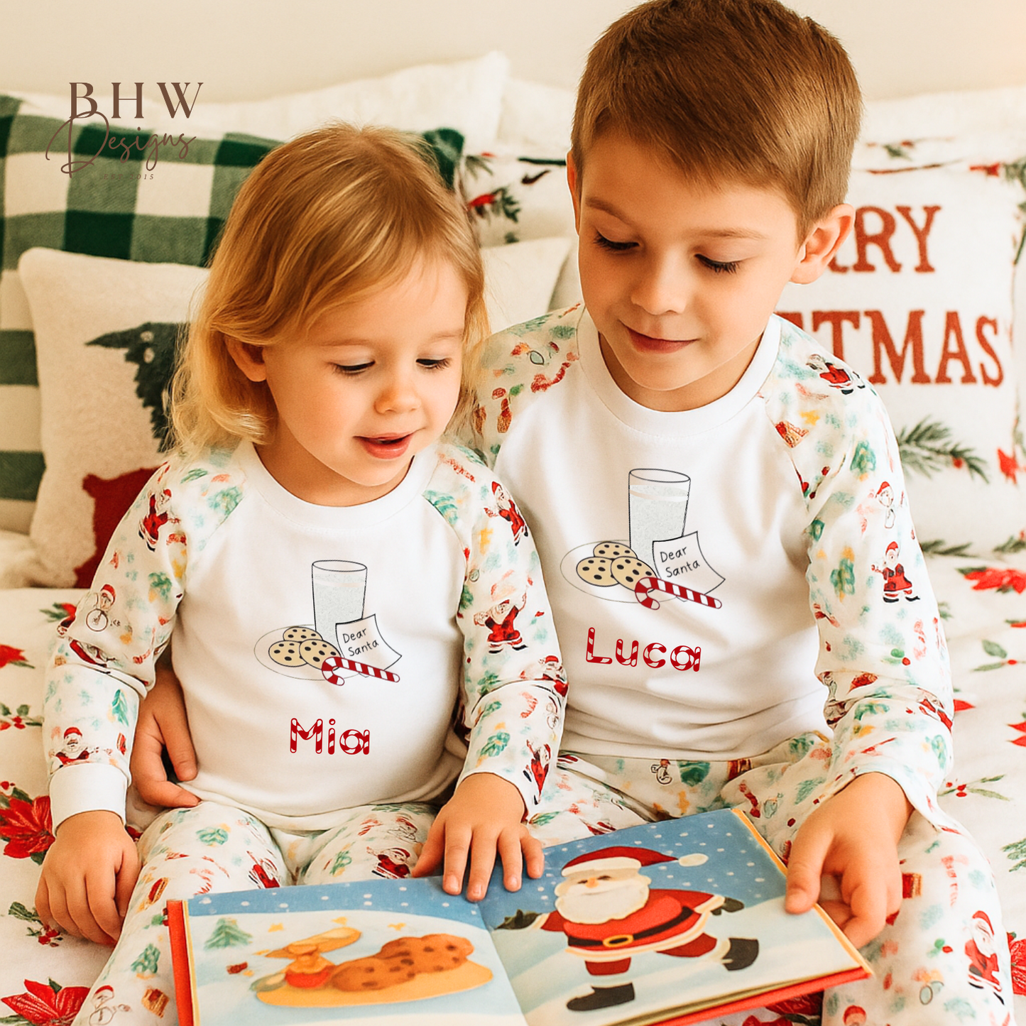 Two children in matching pajamas reading a Christmas-themed book on a festive couch.