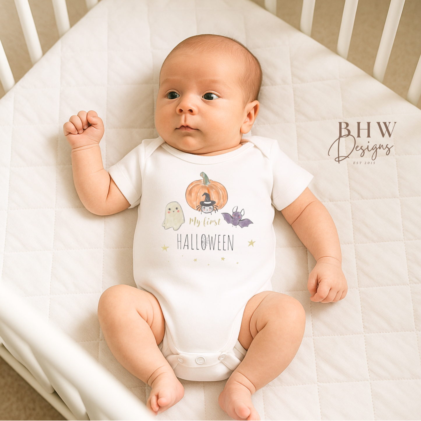 Baby wearing a 'My First Halloween' onesie in a crib