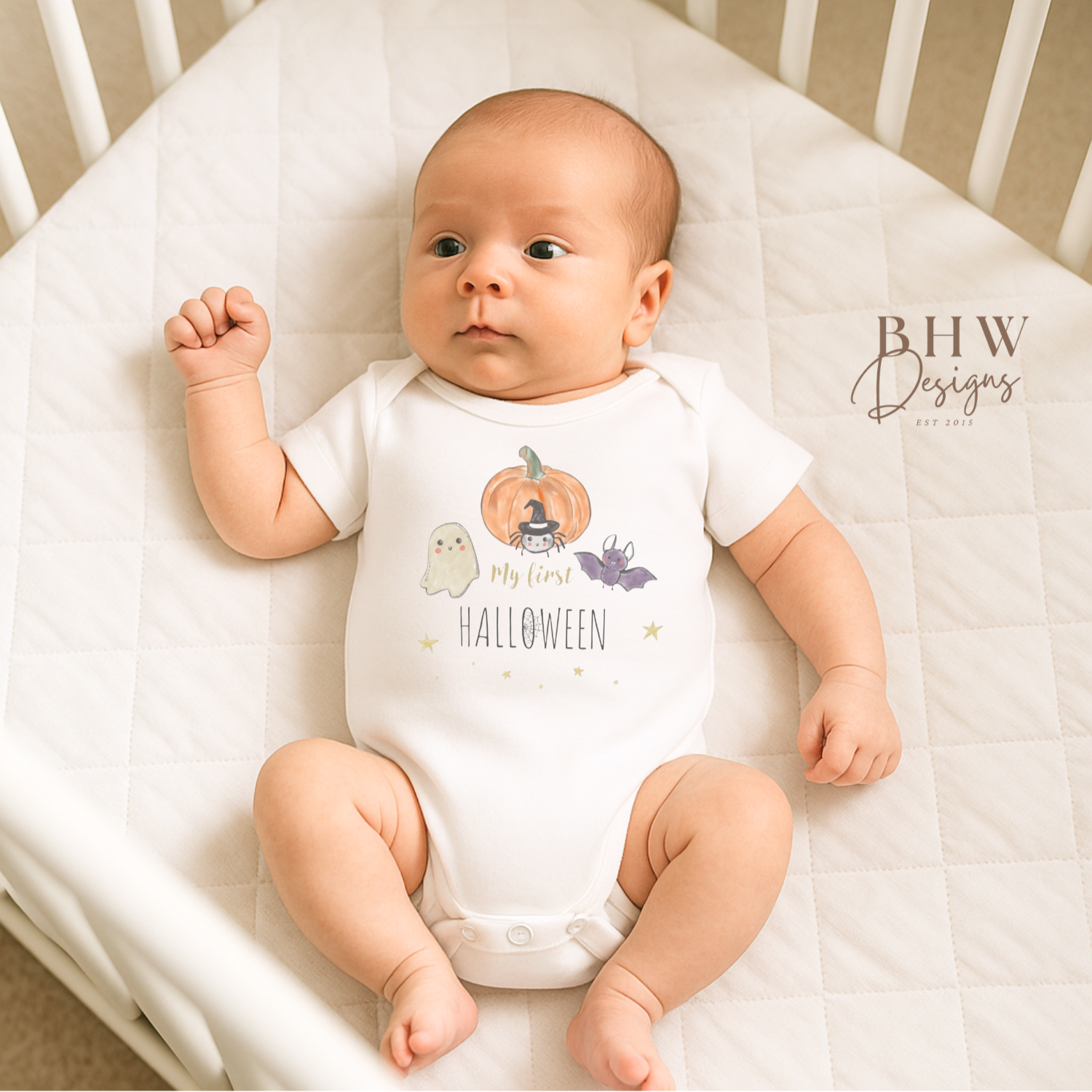 Baby wearing a 'My First Halloween' onesie in a crib