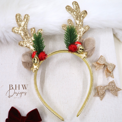 Gold reindeer antler headband with green pine cones and red berries on a white background, featuring BHW Designs branding.