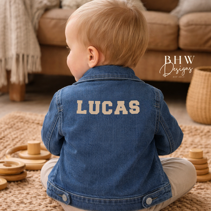 Child wearing a blue denim jacket with 'LUCAS' on the back in beige