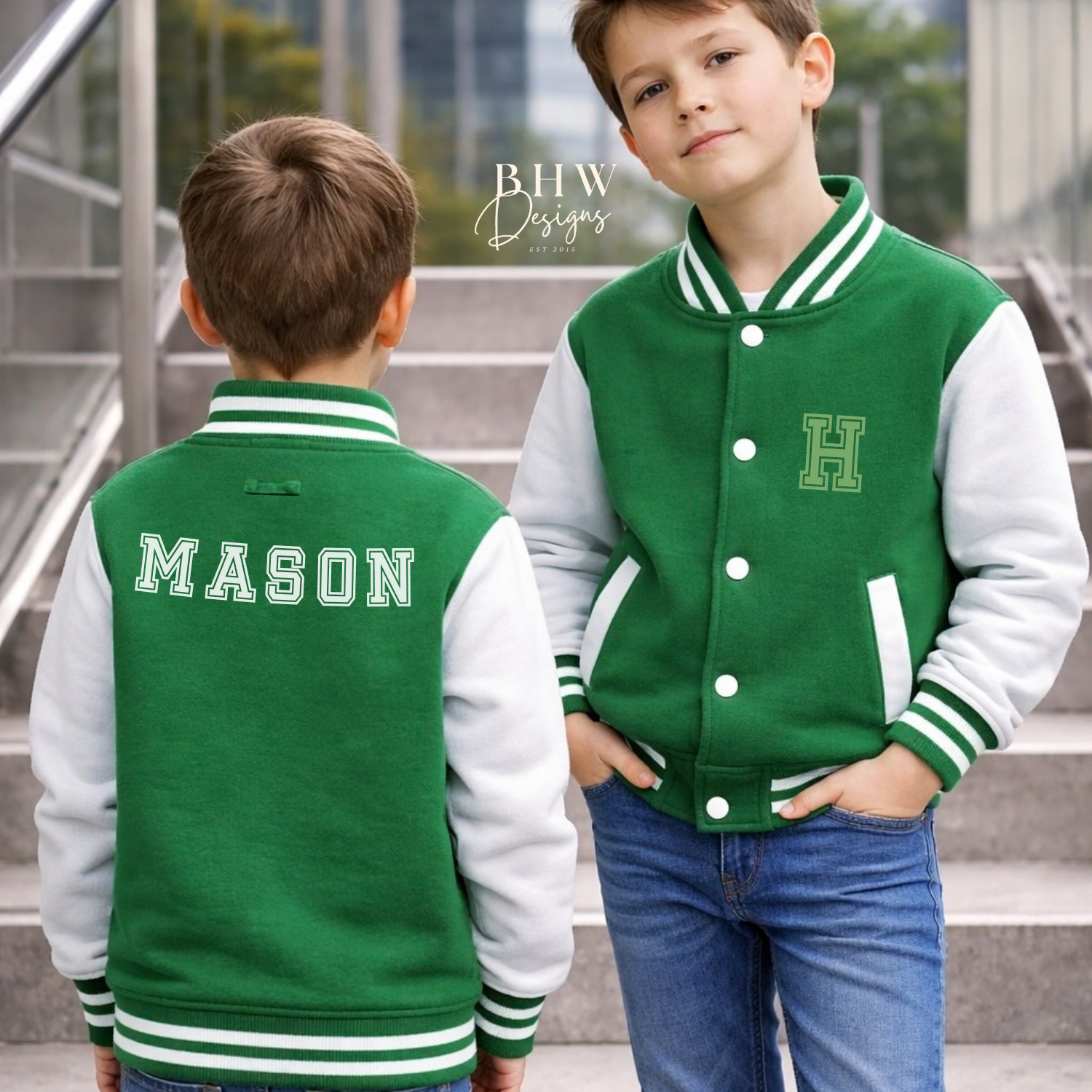 Two children wearing green and white letterman jackets with 'MASON' and a initials 'H' on a city street background.