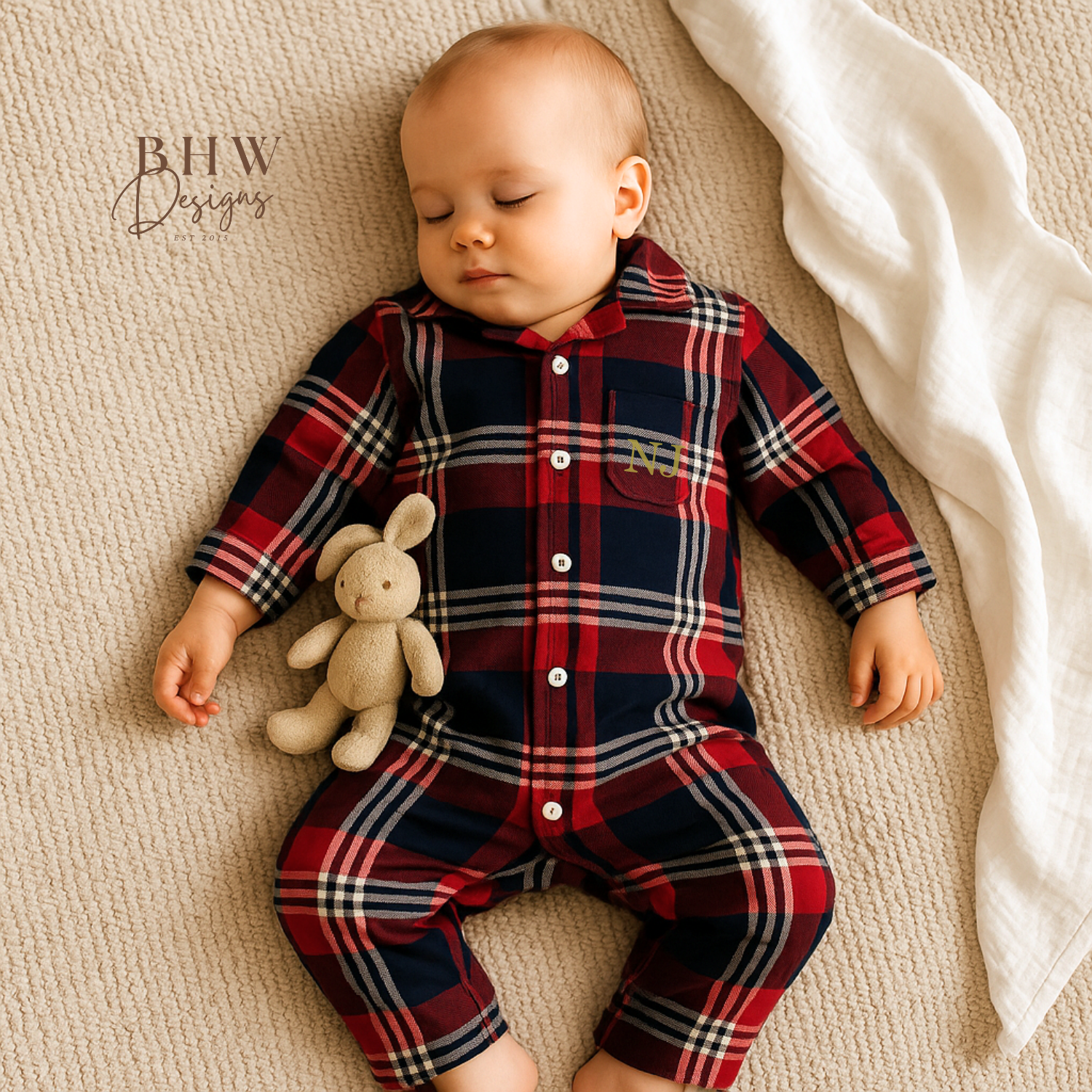 Baby wearing a red and blue plaid onesie with 'NJ' in gold on the front
