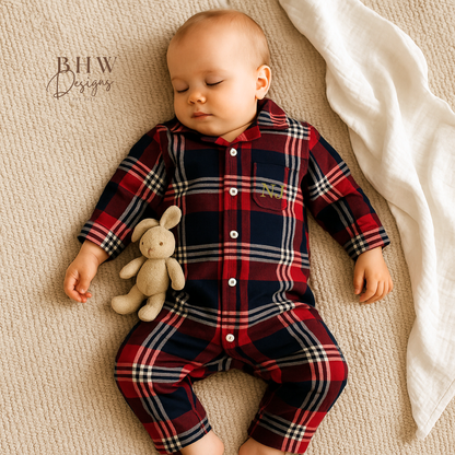 Baby wearing a red and blue plaid onesie with 'NJ' in gold on the front