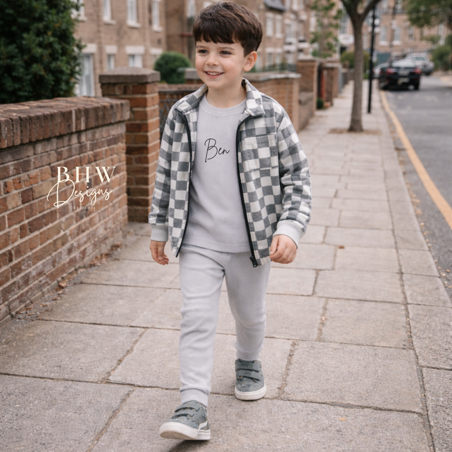 Child wearing a grey checkered jacket and a personalised grey ribbed loungewear set sidewalk