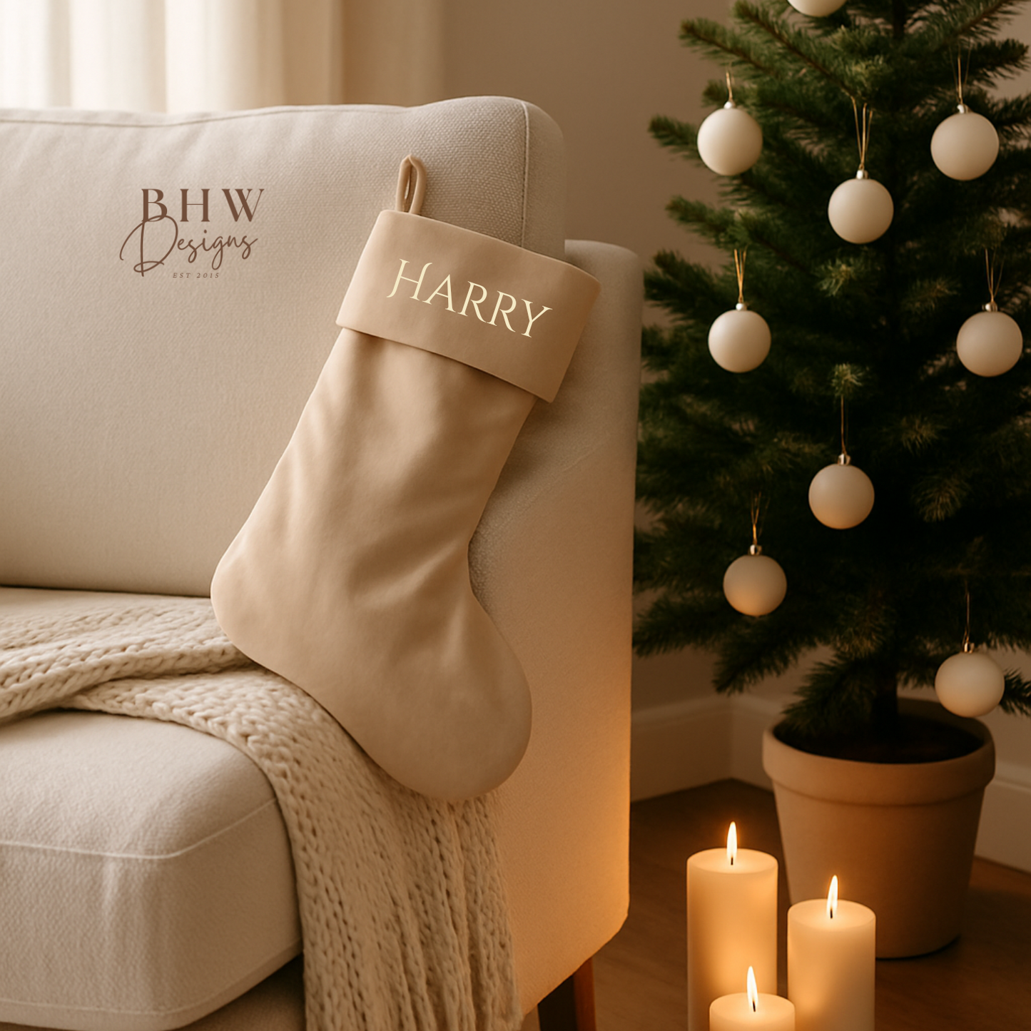 Beige Christmas stocking with 'HARRY' on a beige armchair next to a decorated Christmas tree.
