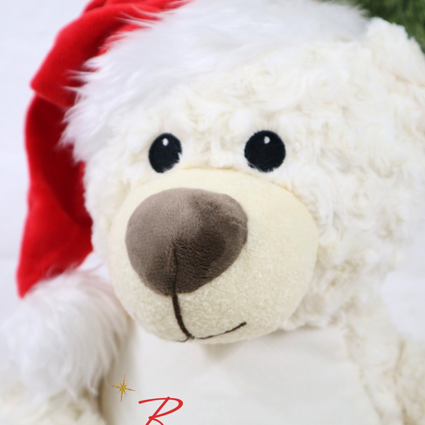 Cream teddy bear wearing a red Santa hat with 'Bonnie's First' text on a light background.