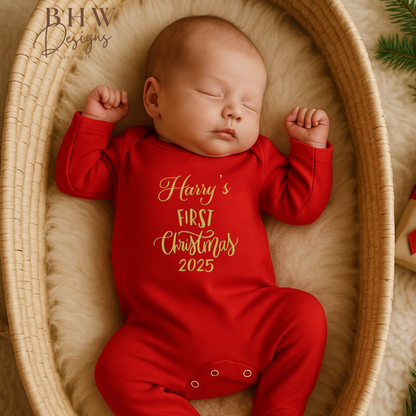 Newborn baby in a red 'Harry's First Christmas 2025' onesie lying in a woven basket.
