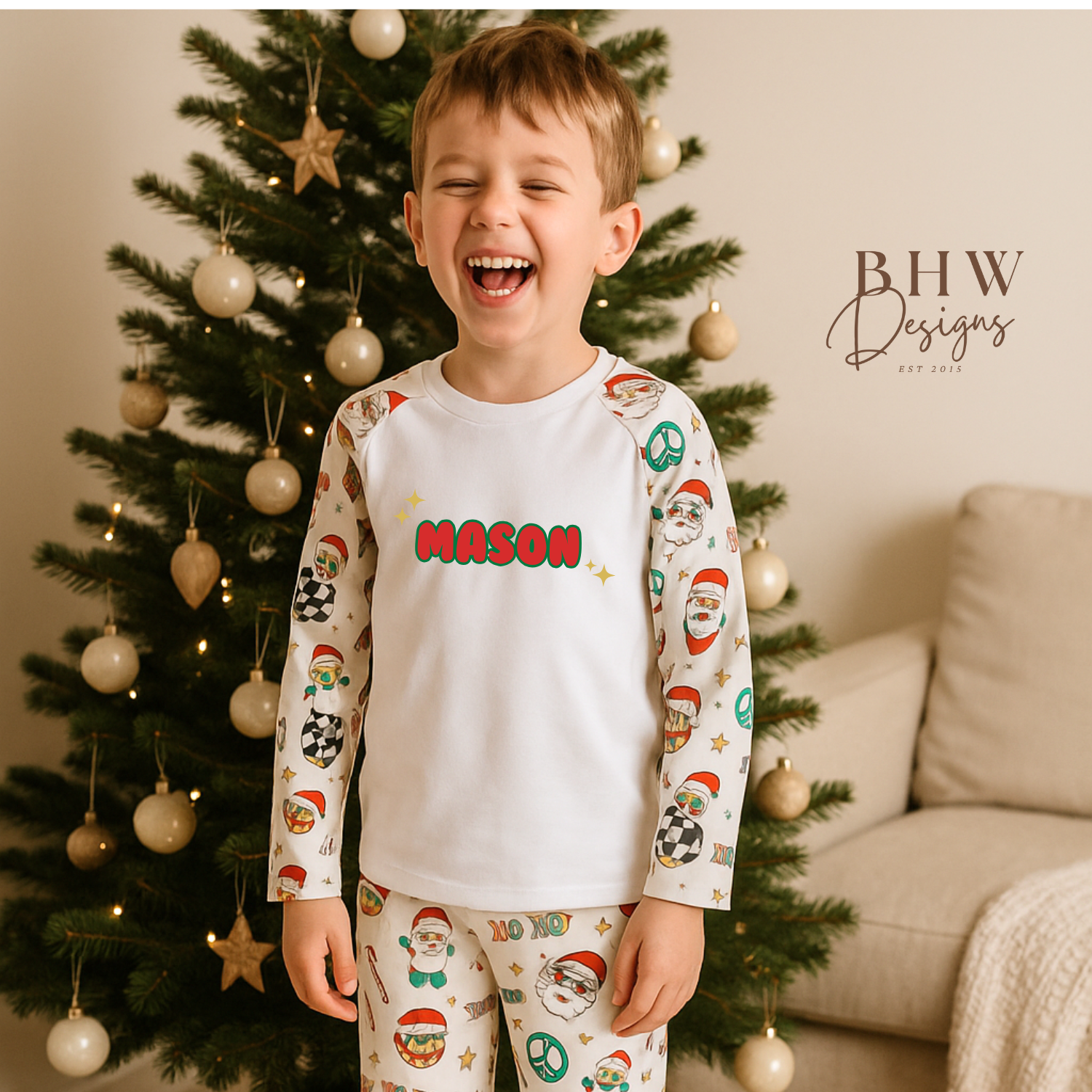Child wearing Christmas-themed pajamas with 'MASON' printed on them, standing in front of a decorated tree.