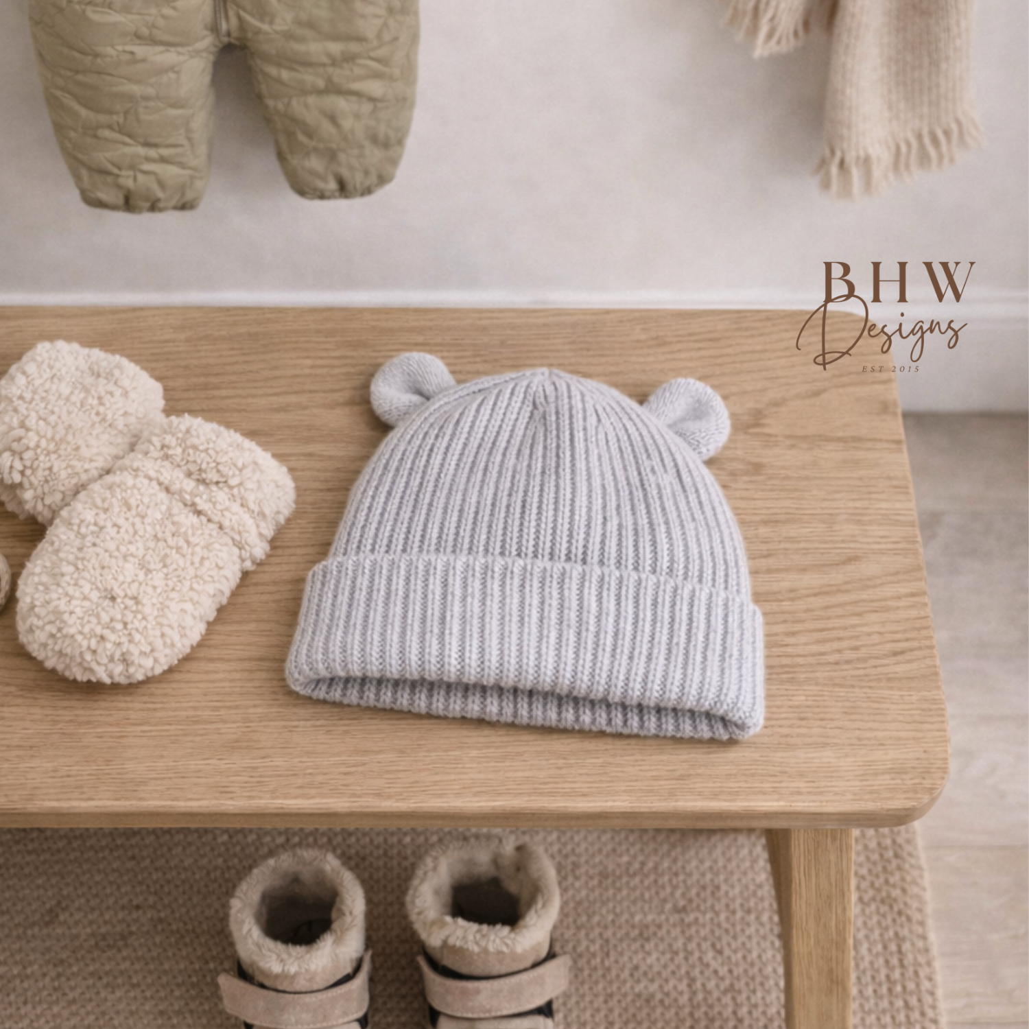 Children's winter clothing including a hat, mittens, and boots on a wooden bench