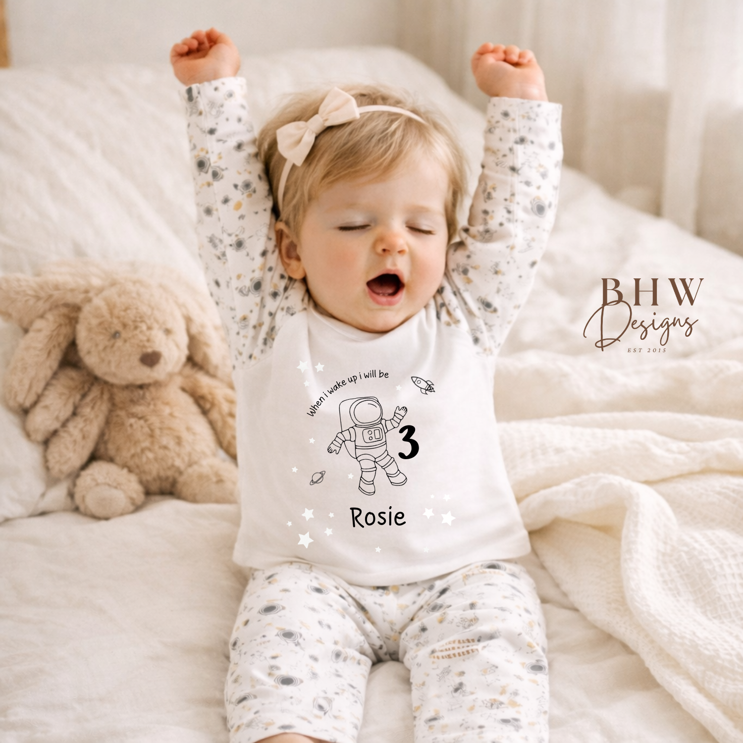 Baby wearing space theme pyjamas personalised with age and name