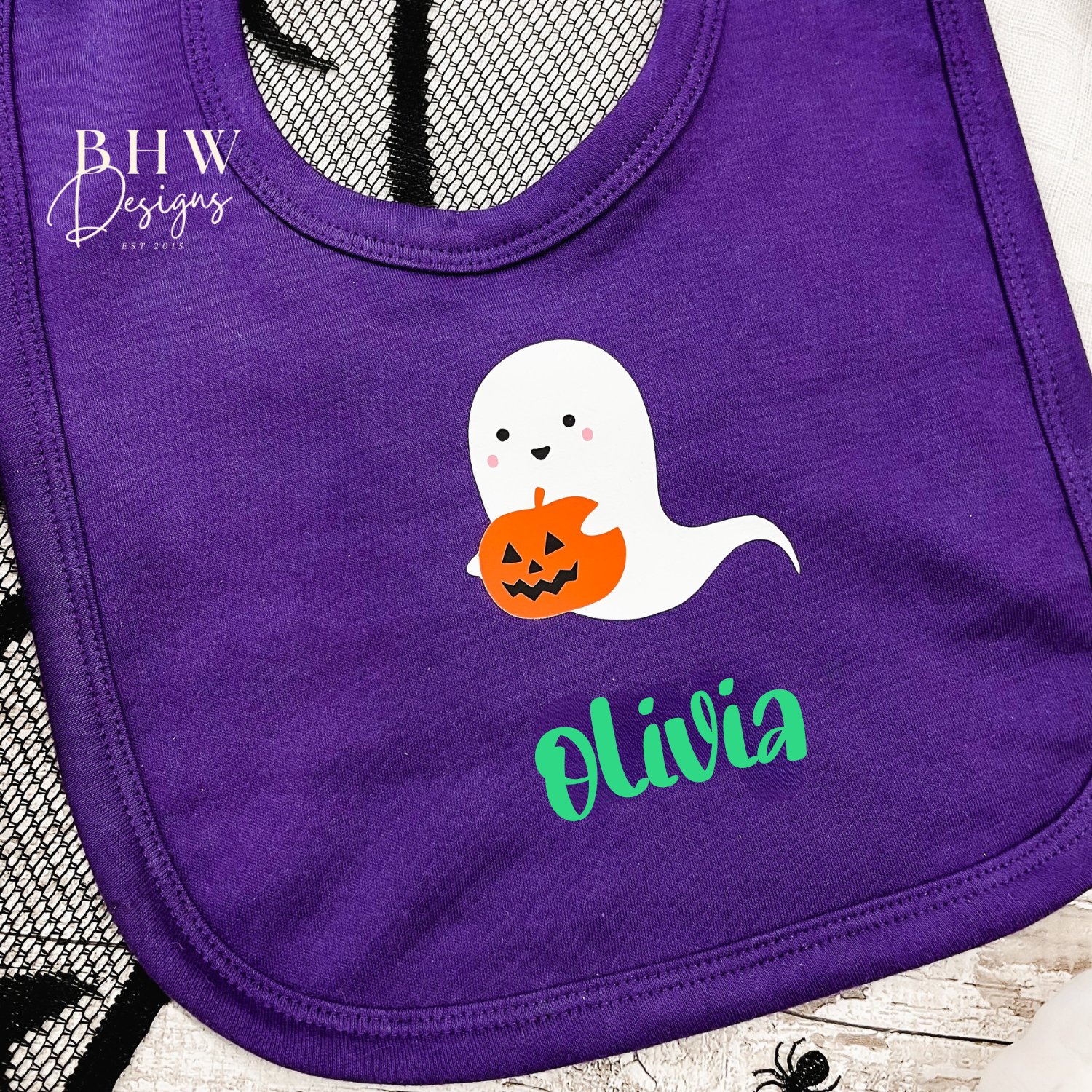 Purple bib with ghost holding a pumpkin and personalised with the name 'Olivia' 