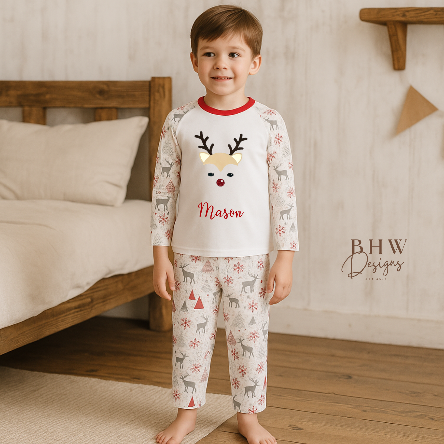 Child wearing a pyjama set with a reindeer design and 'Mason' text, standing in a bedroom.