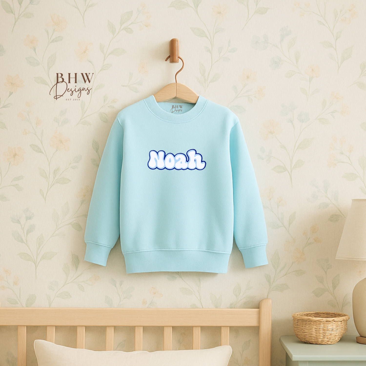 Light blue sweatshirt with 'Neon' text on a hanger against a neutral wall.