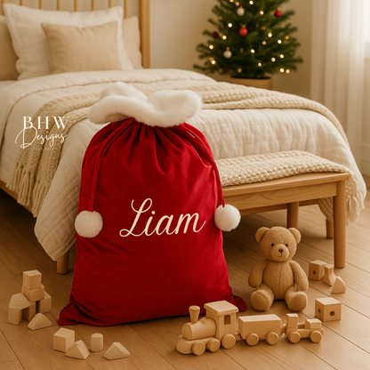 Red sack with 'Liam'  on a bed with Christmas tree in the background