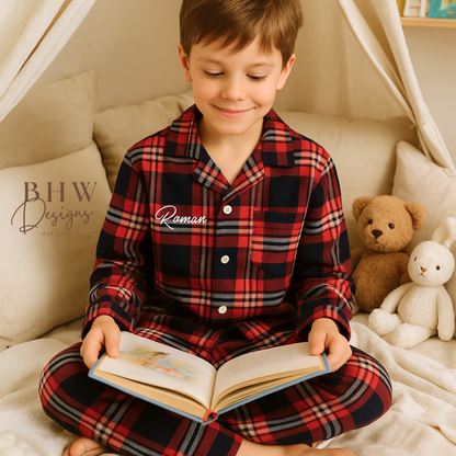 Child wearing a red, navy and white plaid pyjamas personalised with name on the front. 
