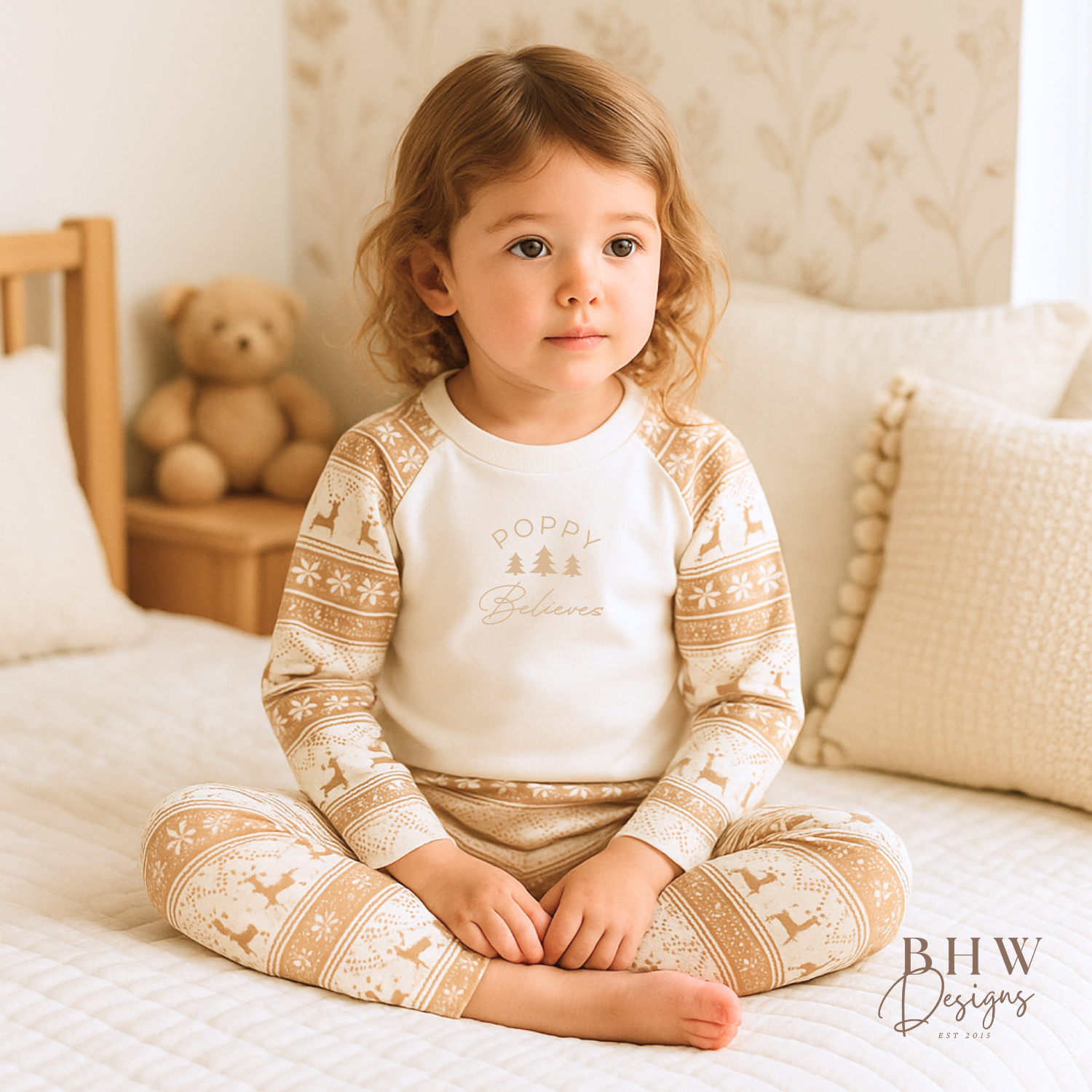 Child wearing a pair of beige and white fair isle print pyjama set with personalised name on the front. 