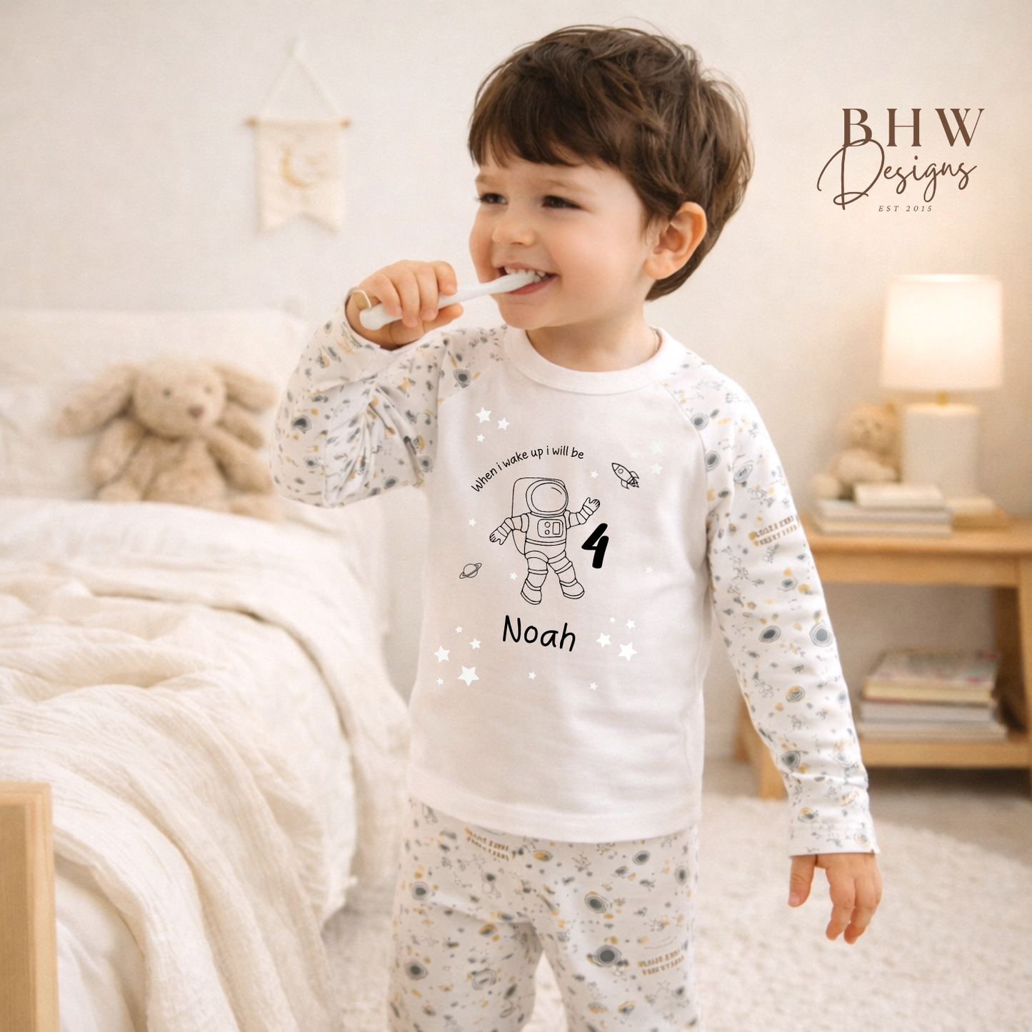 Child brushing teeth wearing a pajama with personalized design, in a cozy bedroom setting.