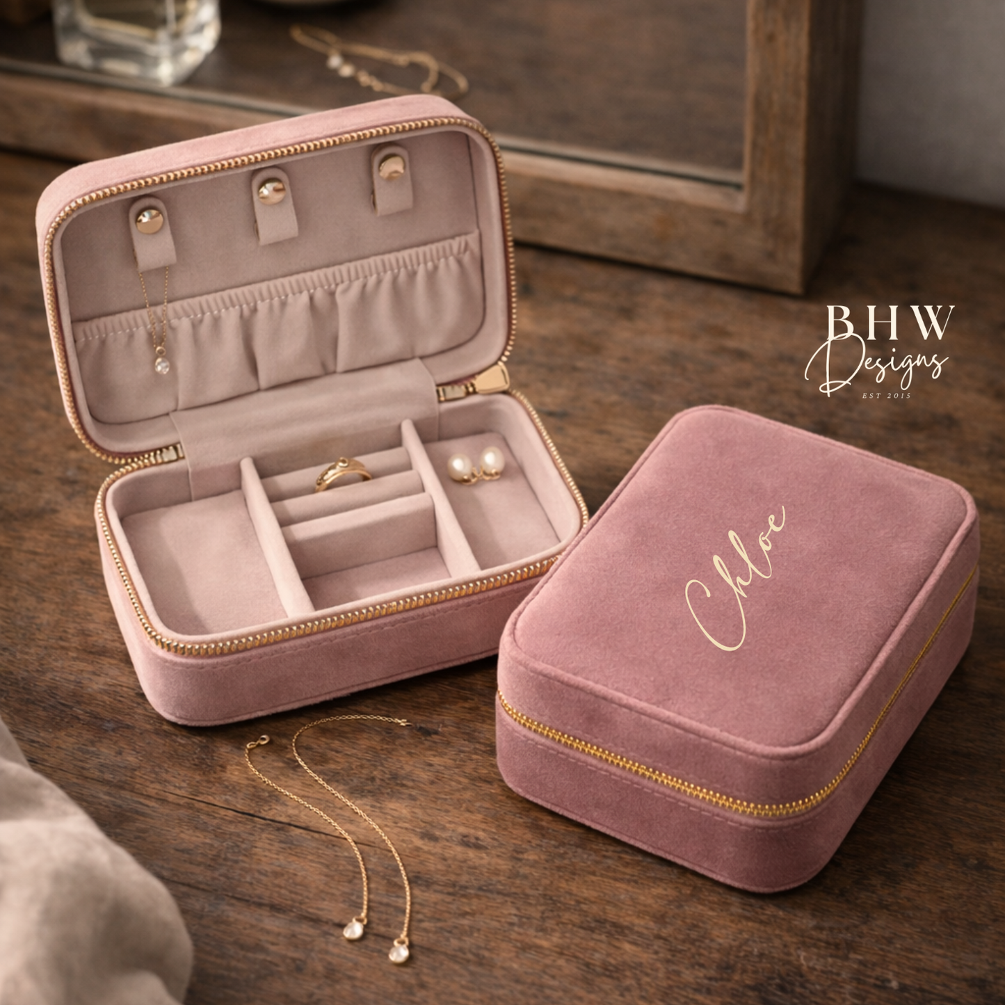 Pink jewellery box with velvet interior on a wooden surface.