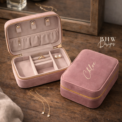 Pink jewellery box with velvet interior on a wooden surface.