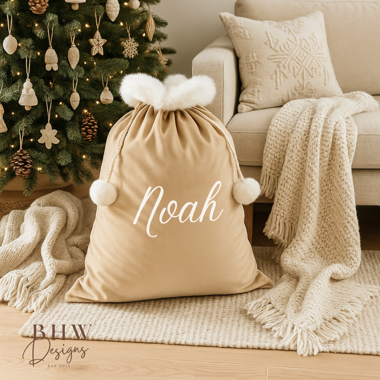 personalised beige velvet Santa sack  it in a cozy living room with a Christmas tree.