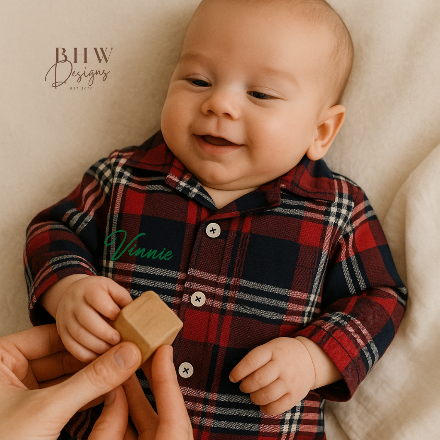 A tartan patterned romper onesie for babies, personalised on the front with a name in script font block.