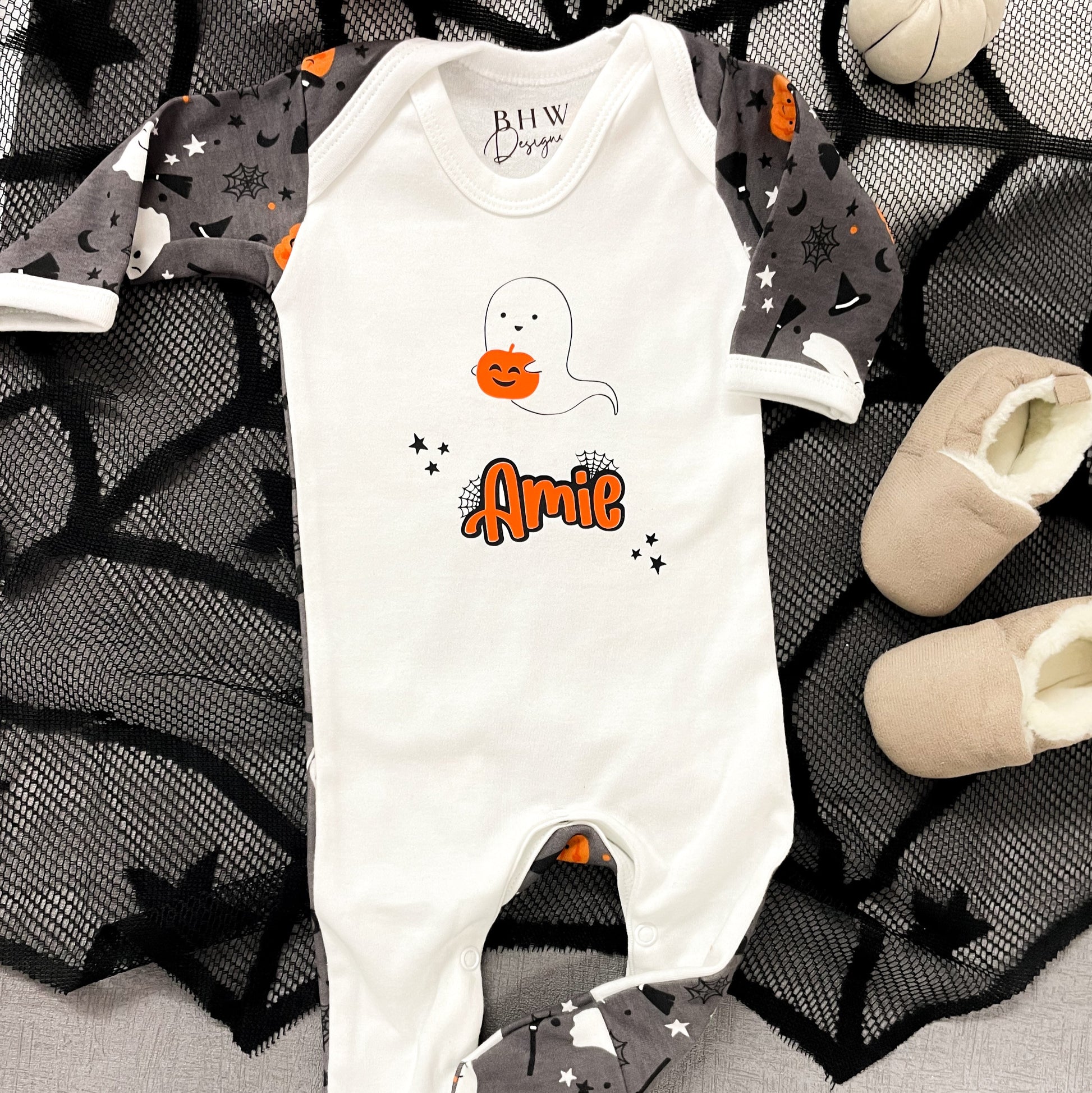 Halloween-themed baby onesie with ghost design and 'Amie' text on a spider web background.