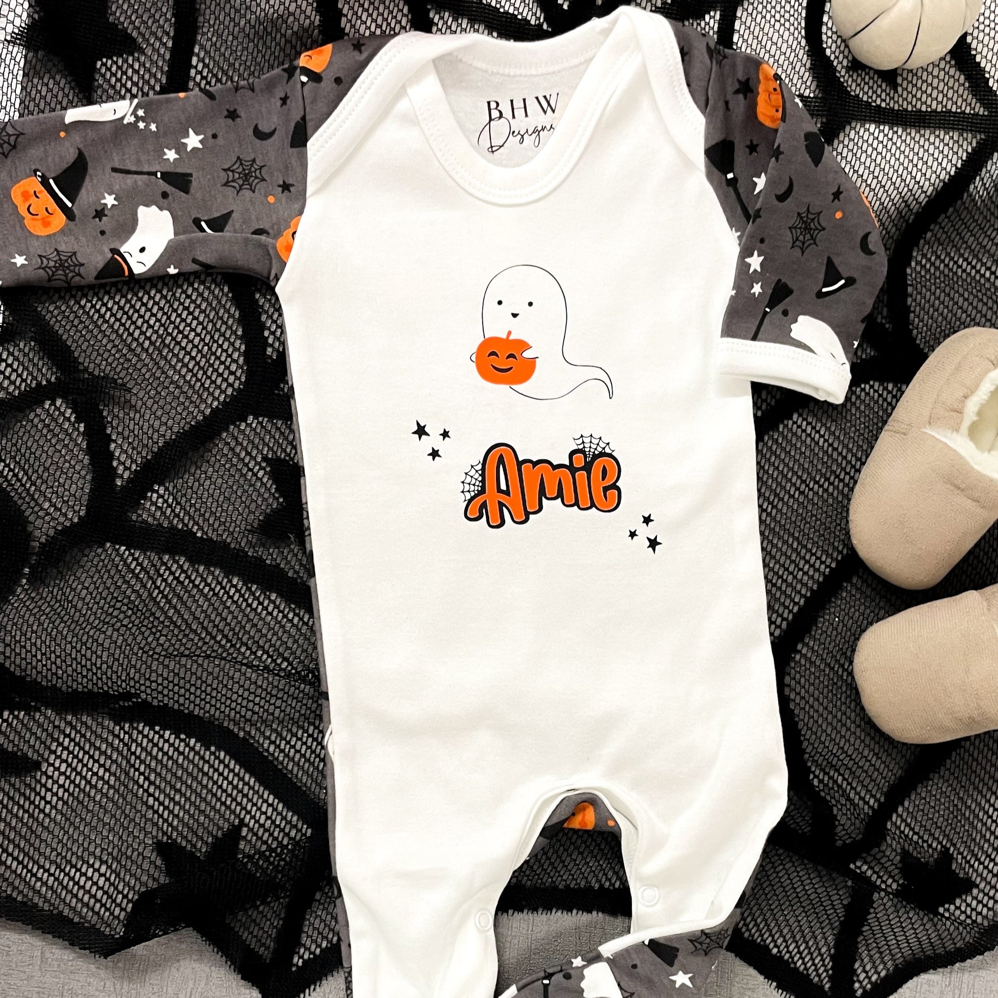 Halloween-themed baby romper with ghost and pumpkin design on a dark background