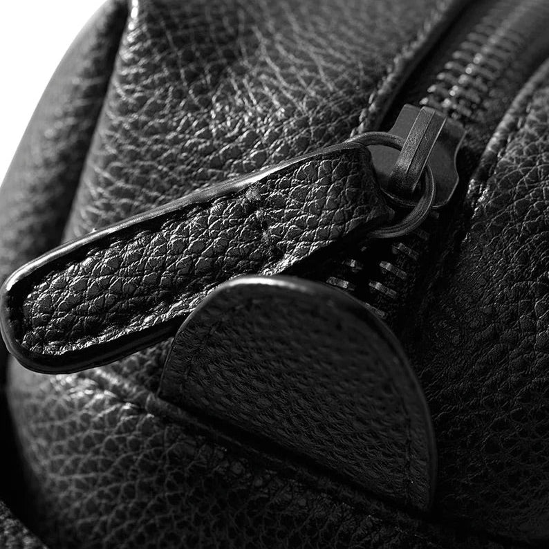 Close-up of a black leather bag with a zipper