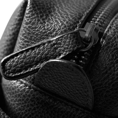 Close-up of a black leather bag with a zipper