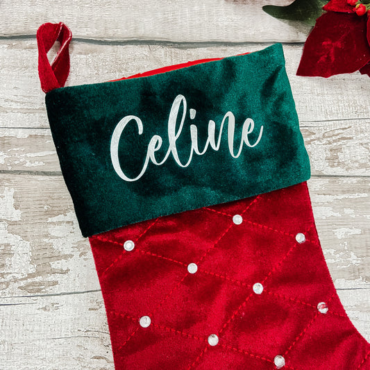 Red and green Christmas stocking with 'Celine' personalised a wooden surface
